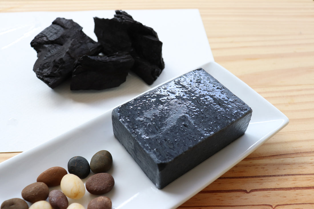 Carbon and activated charcoal soap on wood background