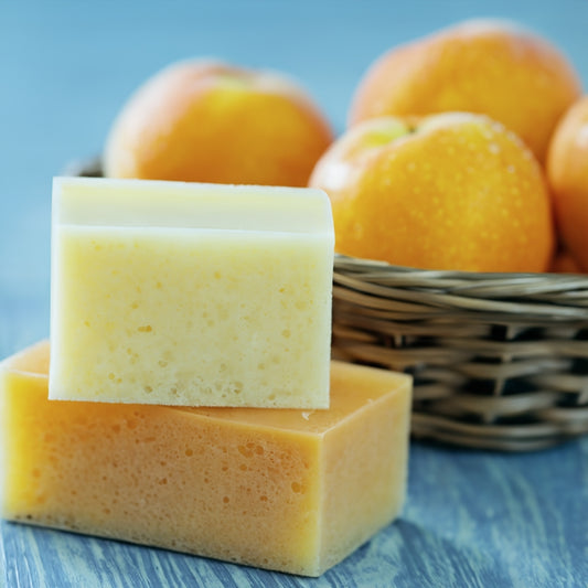 Apricot bar soaps on blue surface next to basket with apricots
