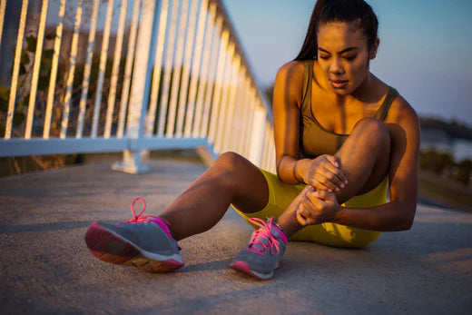 A woman with arthritis, wearing shoes, sits on the ground, symbolizing the difficulties and pain experienced due to the condition.