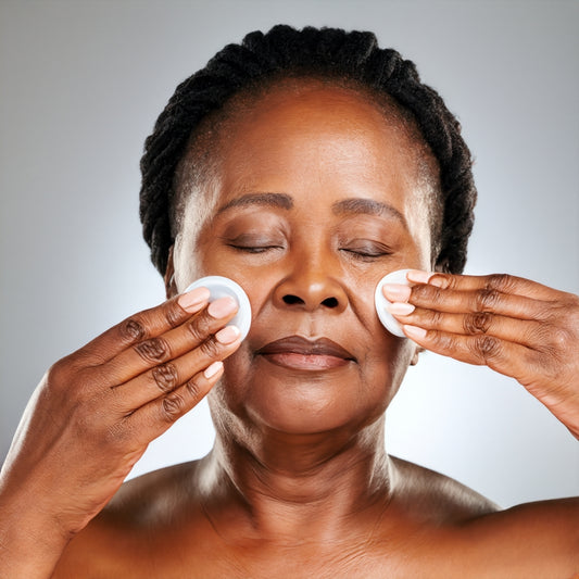 An older woman with her hands on her face, showcasing the best skincare for mature skin.
