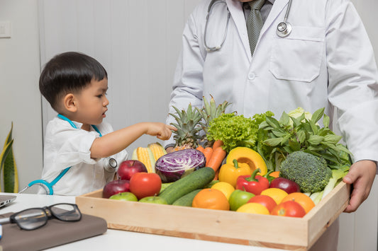 Medical professional supporting child, with box of fruits and veggies. Foods to lower blood pressure.