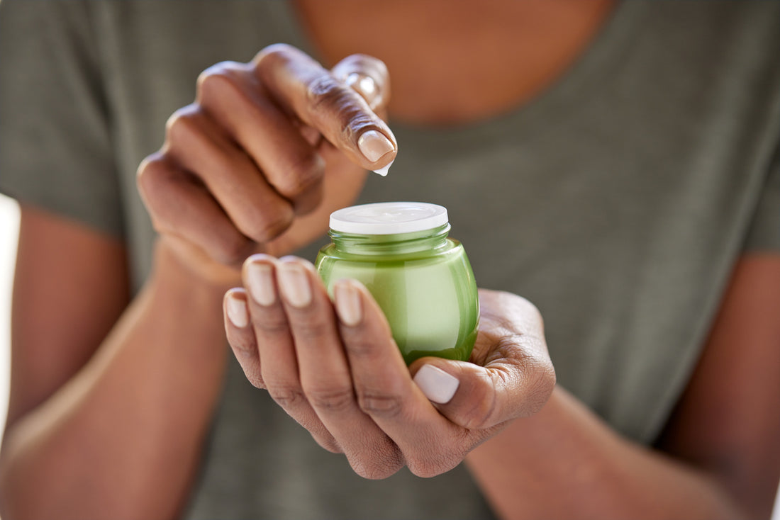 Greater mood collagen moisturizer in green jar in woman's hand
