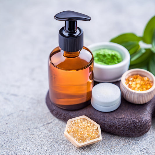 A bottle of anti aging oil, a jar of honey, and a small container of green powder on a wooden table.