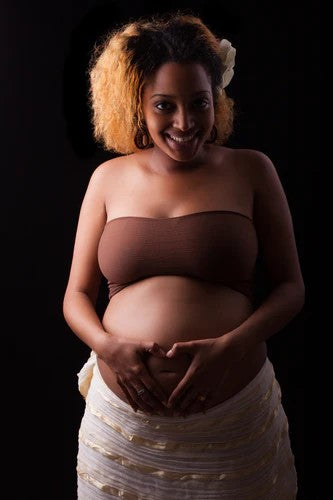 Image of a pregnant woman wearing a brown top and skirt.