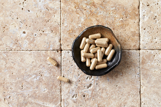 Ashwagandha (Withania somnifera) capsules in a container on a tiled surface