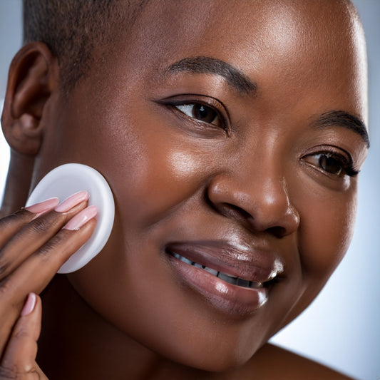 black woman cleaning face with sponge 