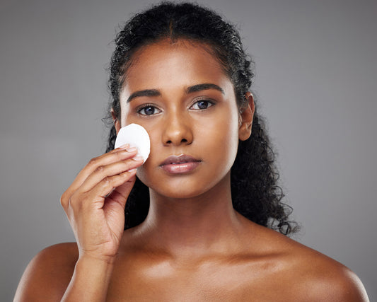 Black woman  model  Face and skincare exfoliating her skin in studio on a gray background