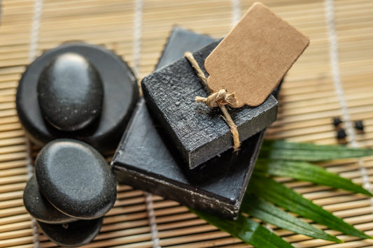 charcoal coal soap on a bamboo background with lava stones