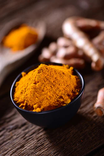 Turmeric powder in a bowl on a wooden table. Enhance your health with the benefits of black turmeric.