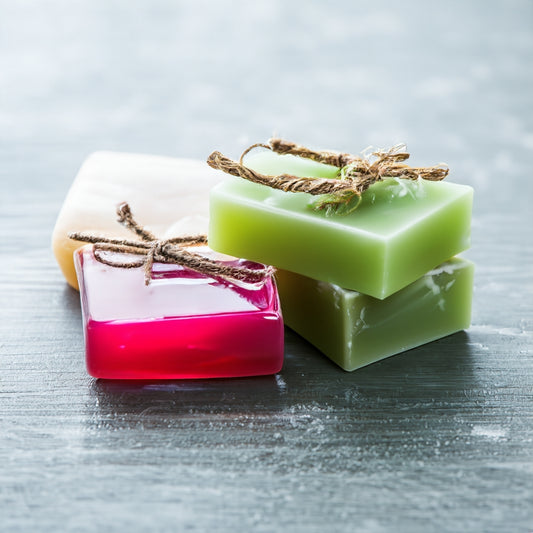 Four luxury soap bars on a gray surface 