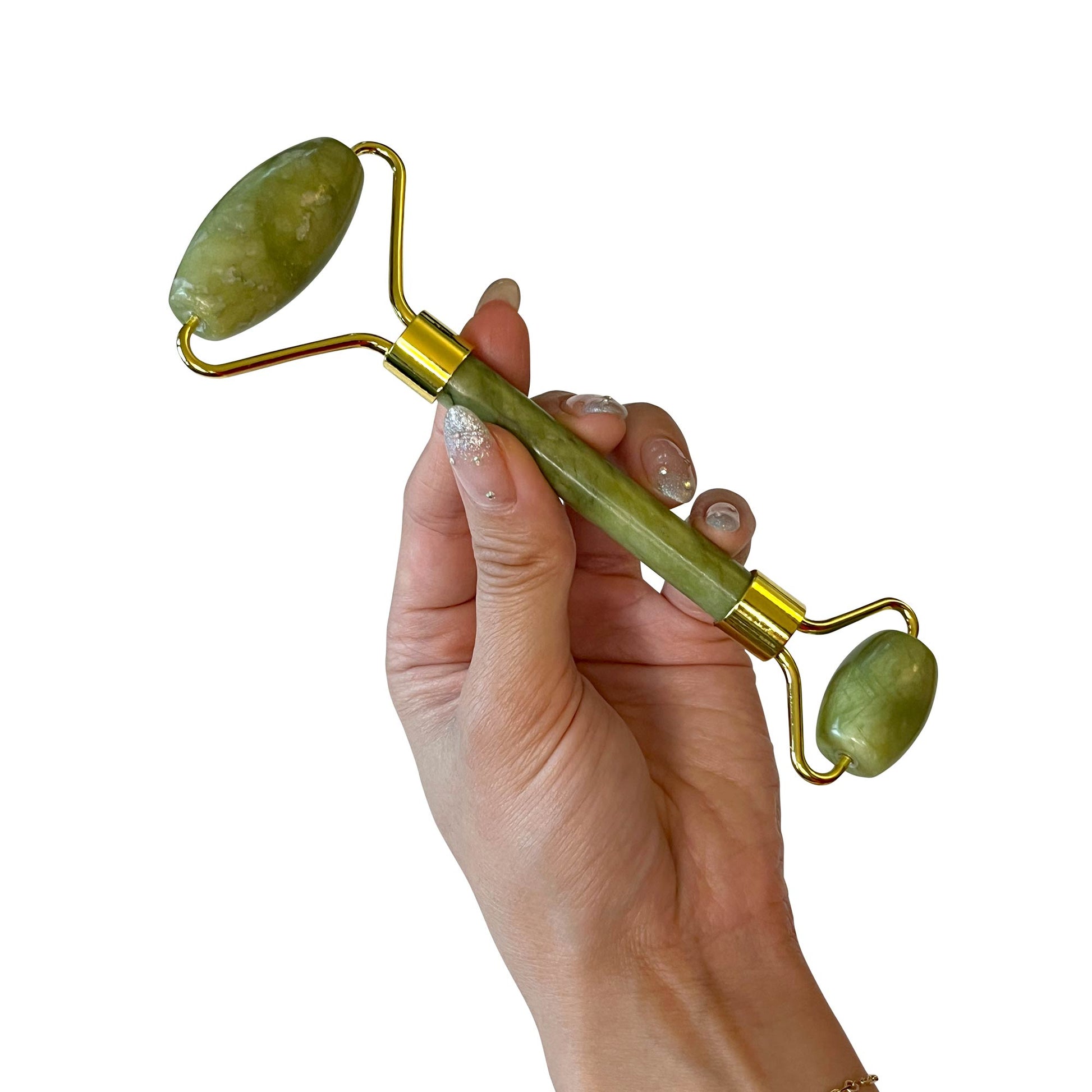 A hand holding a green jade roller, a stone massager used for relaxation and skincare.